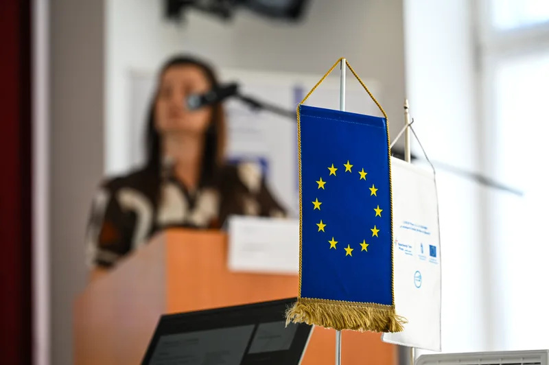 Előadó és zászló a munkáltatói fórumon